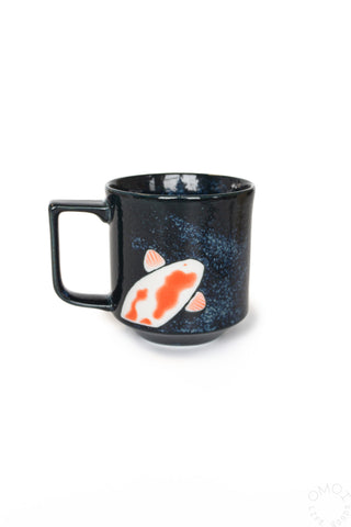Black ceramic mug with koi fish design, wide handle view