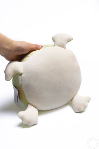 Small plush frog hugging pillow back view, white back with curled frog feet