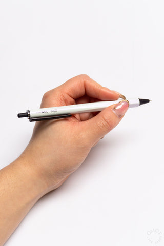 Pearl white OHTO GS02 0.5mm gel pen held in a hand