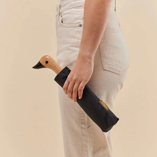 Black compact duck umbrella with wooden duck handle, held by the grip