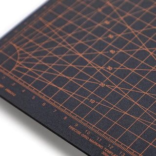 Close-up of dark A5 cutting mat with orange crosshatch grid