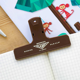 Plastic binder clip, brown, clipped to worksheet with printed illustrations