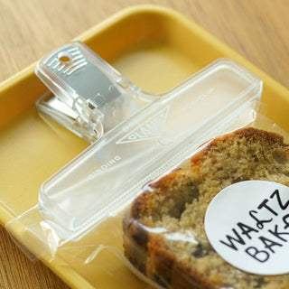 Clear plastic binder clip holding snack bag