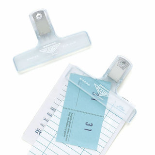 Clear plastic binder clips securing papers