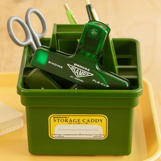Green plastic binder clip in a storage caddy with compartments