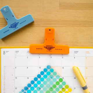 Plastic binder clips set, blue and orange, clipped on planner pages