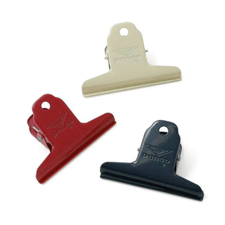 Assorted steel binder clips in cream, red, and navy