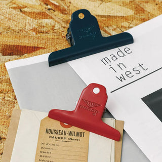 Navy steel binder clip holding papers and a card