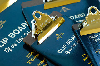 Gold metal clipboard clip on blue clipboard cover