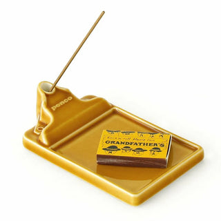 Brown ceramic incense holder tray with incense stick in back hole and logo