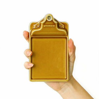 Brown ceramic incense holder held in hands, showing front logo and tray opening