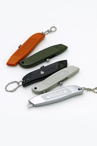 Assorted pocket utility knives with keychain lanyards in orange, green, black, and gray