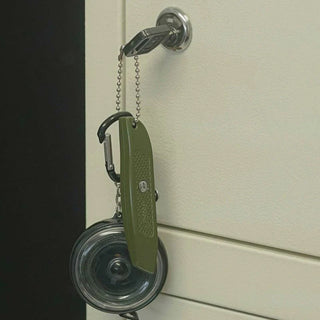 Olive green pocket utility knife with keychain lanyard on a wall hook