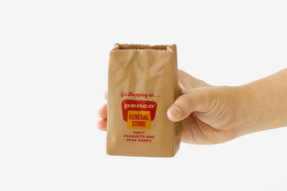 PENCO brown paper bag pen holder held in a hand with front logo