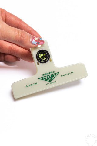 Cream plastic binder clip held in hand