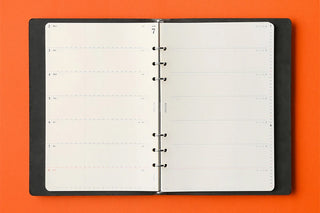 A5 weekly schedule diary refill opened in binder, two-page spread with black rings