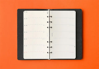 Opened weekly schedule refill binder showing punched pages on both sides