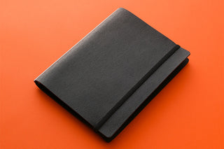 A5 dark gray notebook with wrap band and card slot, closed view
