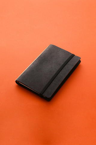 Black Bible-size notebook with elastic band, smooth cover and minimal design