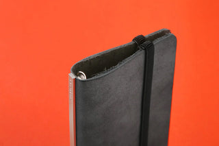 Dark fabric holder with metal grommet and black strap loop