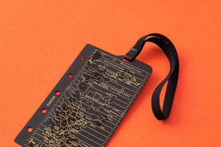 Dark circuit-printed band with attached black wrist strap, hole-punch edge