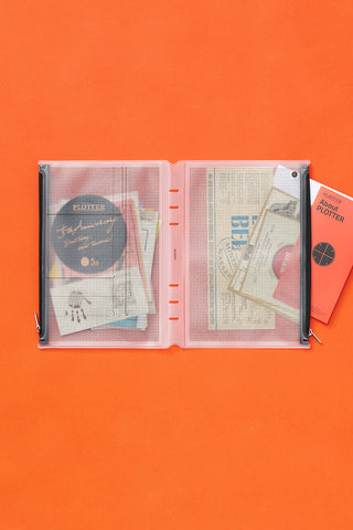 Opened PLOTTER A5 fastener case with gray grid inserts and metal rings, black cover