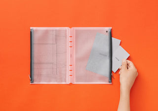 PLOTTER A5 fastener case open with gray grid inserts and hands holding a loose sheet