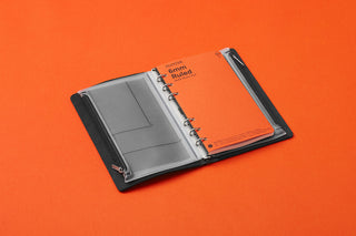 Dark gray fastener case opened, perforated pockets with metal rings and binder spine