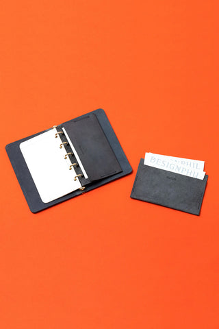 Leather card case with dark gray cover, open binder rings and card pocket
