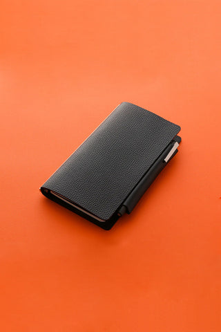 Dark narrow leather penholder with textured finish and small slot on side