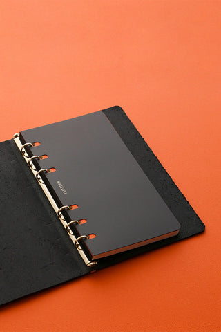 Black Bible-size ring binder with metal rings, planner cover and rings exposed