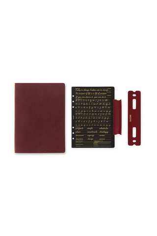 A5 leather binder set in deep red-brown with cover, insert sheet, and closure strap
