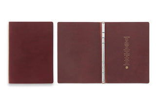 Open A5 red-brown leather binder with metal ring spine and printed index page