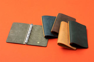Leather 5-ring binders in navy and tan with metal ring mechanisms