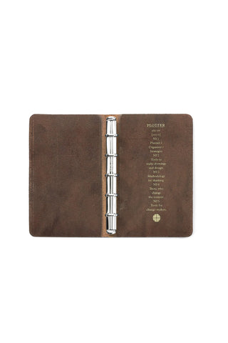 Open brown leather mini 5-ring binder showing metal rings and inner label