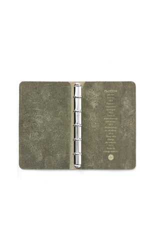 Green leather mini 5-ring binder open, showing silver ring mechanism and inner text