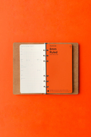 Beige leather 6-ring binder with ruled pages, open on rings