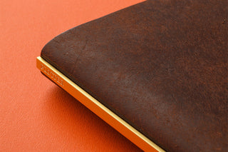 Brown leather binder spine with gold edge trim