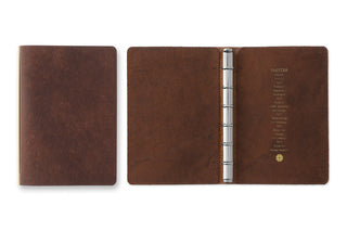 Brown leather mini binder open flat, metal 6-ring spine centered