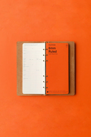 Open beige narrow 6-ring binder with ruled pages and metal ring mechanism