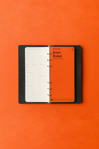 Open black 6-ring leather binder with ruled planner pages and metal rings