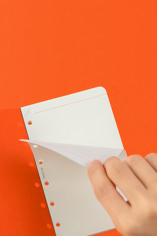 White memo pad sheets with dot-and-line perforations, held by a hand