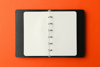 Refill memo pad inserted into a ring binder, showing white pages and punched spine