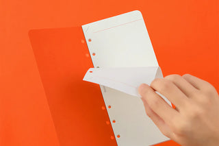 Narrow 2mm grid memo pad refill open, showing punched holes and pages