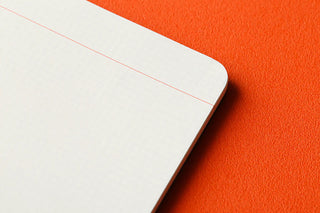 Corner of white 2mm grid memo page with red grid line