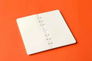 Open narrow memo pad refill with white pages and punched binding holes