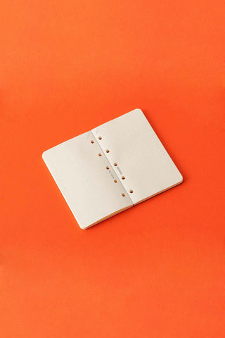 Mini-5 memo pad refill with white dot-grid pages, folded open, orange background