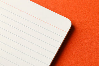 White ruled memo pad pages with red margin line on perforated edge