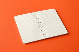 Closed 6mm ruled memo pad refill with white pages and punched holes at center fold
