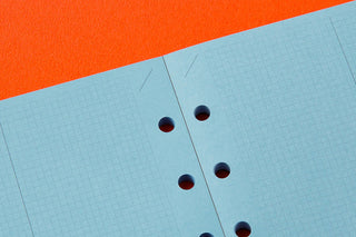Blue 2mm grid graph paper with round punched holes, close-up